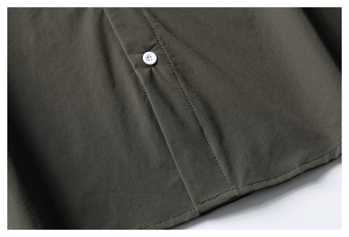 Close-up of the olive-gray shirt front with a white button, placket stitching, and hem.