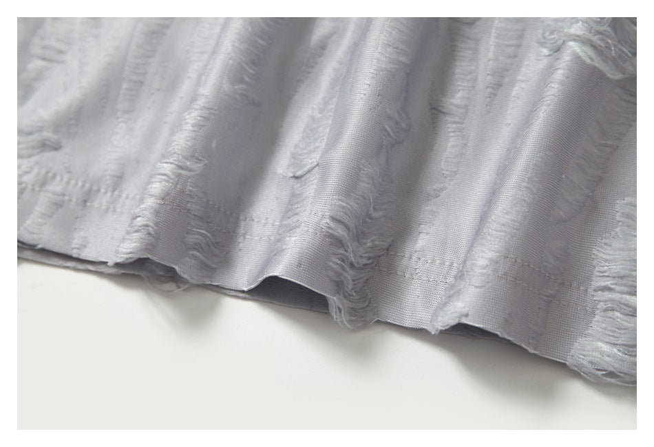 Close-up of the white garment's lower edge and raised wavy stripe texture.