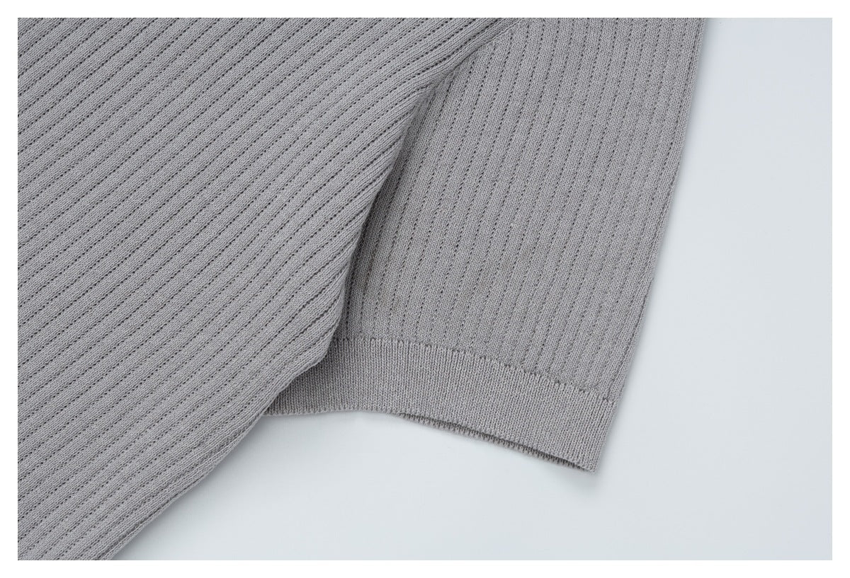 Close-up of a light gray ribbed sleeve and its wide fitted cuff.
