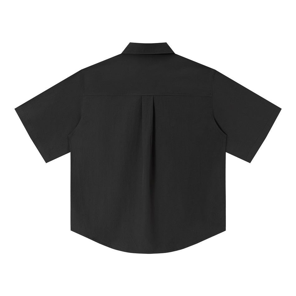Back view of a black short-sleeve button-up shirt with a center pleat and curved hem.