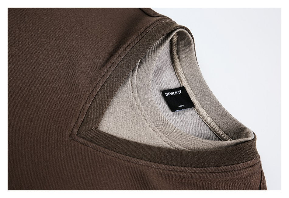Close-up of a brown top's layered neckline and interior with a black DEVILRAY label.