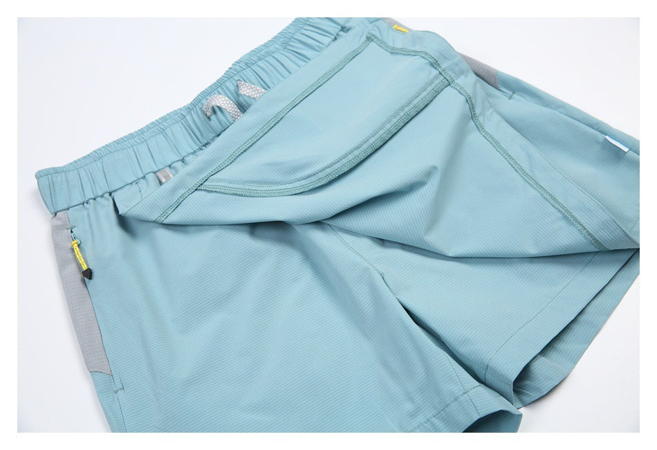 Close-up of light blue shorts with a large flap pocket lifted to show its shape and stitching.