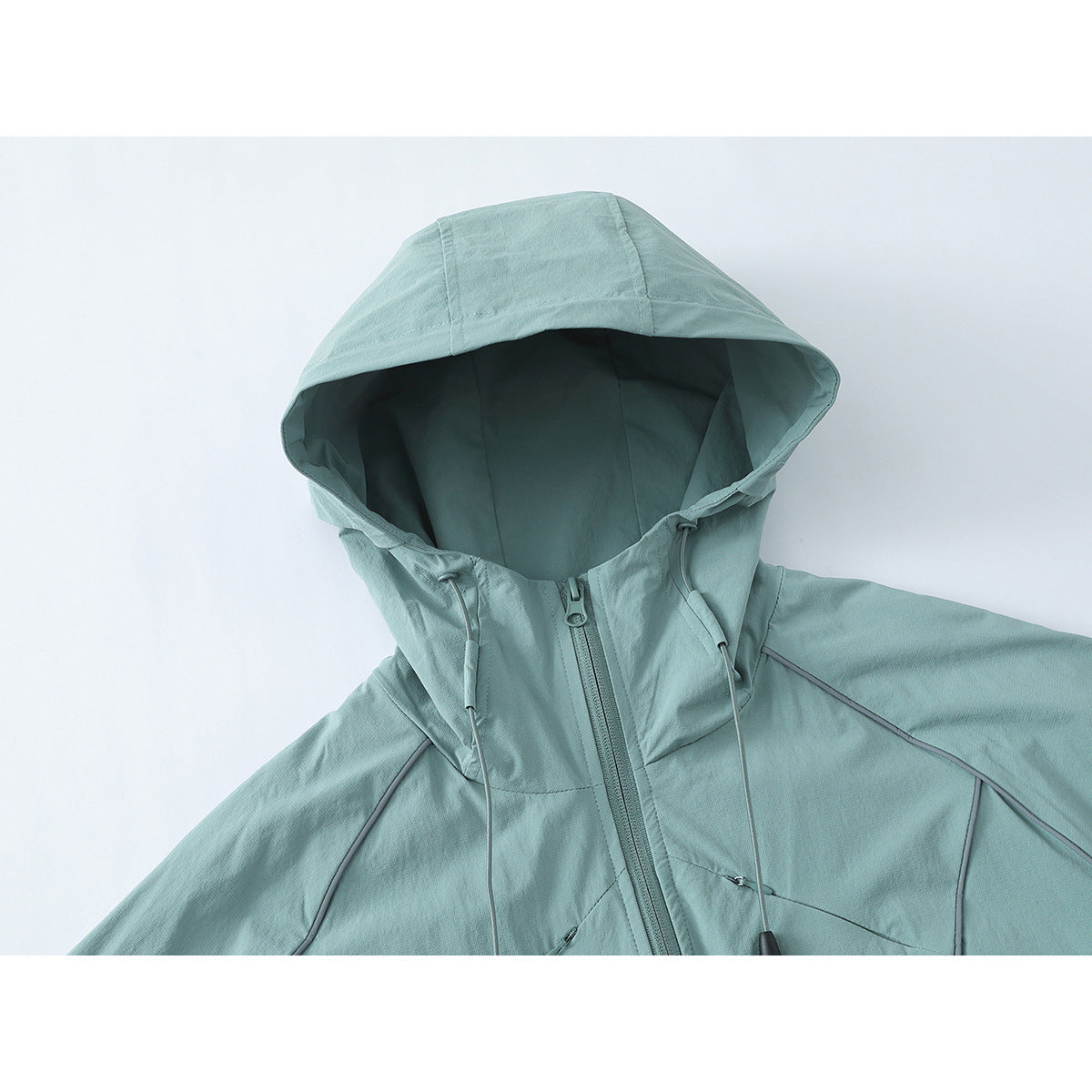 Close-up of a pale aqua hooded jacket showing the hood, front zipper, drawcords and seam details.