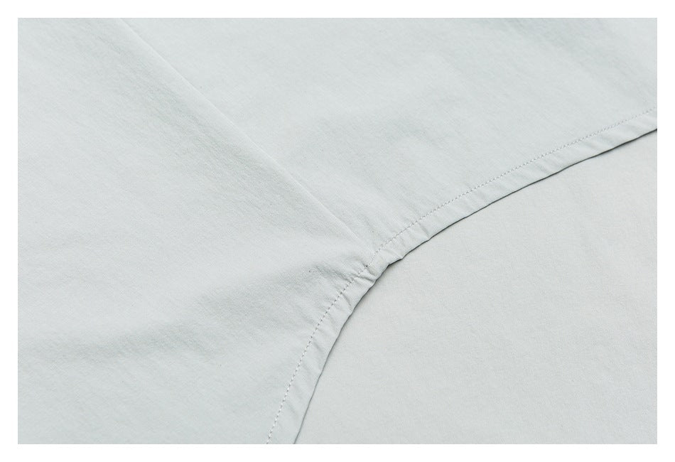 Close-up of pale gray garment fabric with a curved stitched seam.
