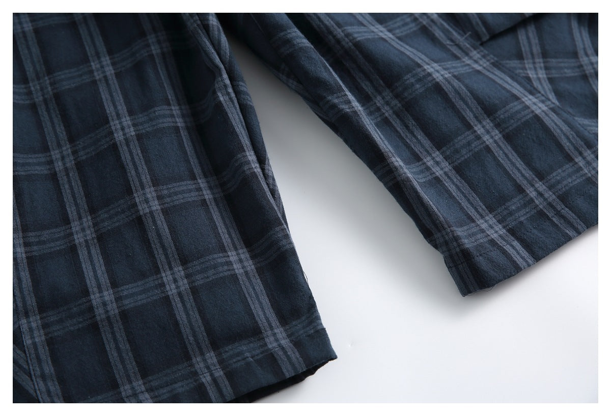 Partial flat lay of dark navy plaid trouser legs, showing the straight cut and hems.