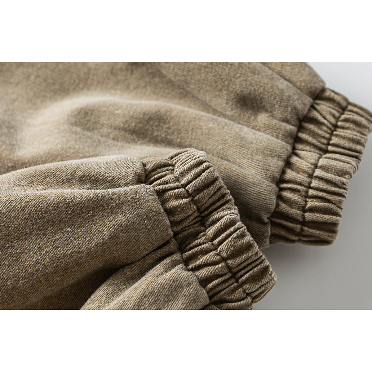 Close-up of gathered elastic cuffs on a tan jacket sleeve.