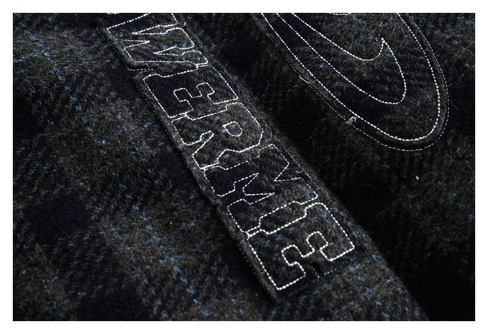 Tight close-up of outlined Nike Air embroidery and swoosh on dark, blue-flecked fabric.