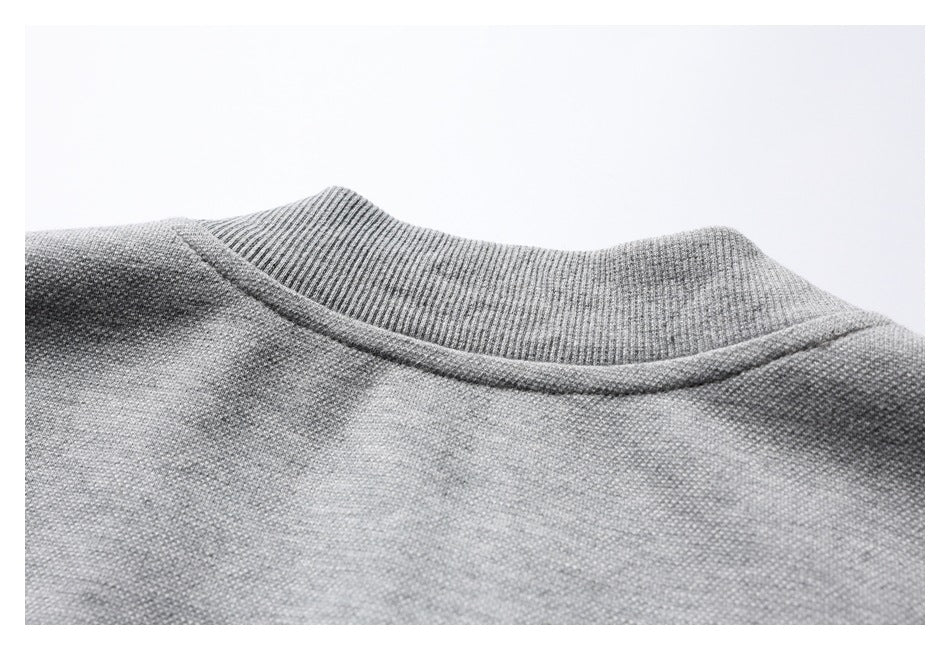 Close-up of a gray garment's ribbed collar and neckline stitching.