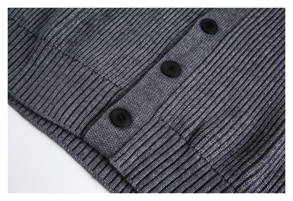 Close-up of the gray ribbed sweater's lower button placket and hem.