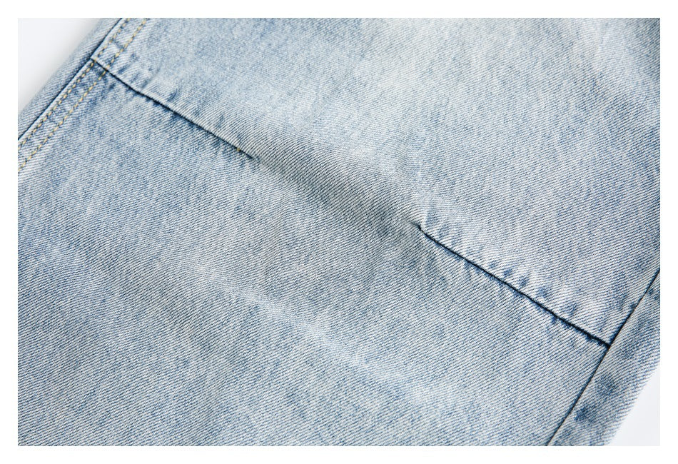 Close-up of light blue denim with a diagonal stitched seam.