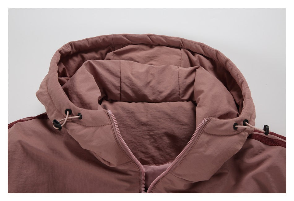 Close-up of a dusty rose jacket's open hood, lining, zipper, and drawcord toggles.
