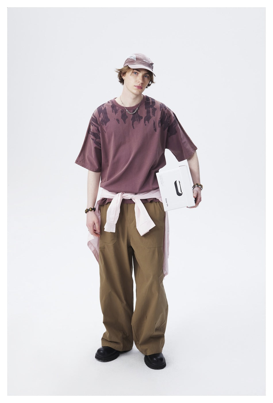Front view of a model wearing a mauve oversized graphic T-shirt and olive wide-leg cargo pants.