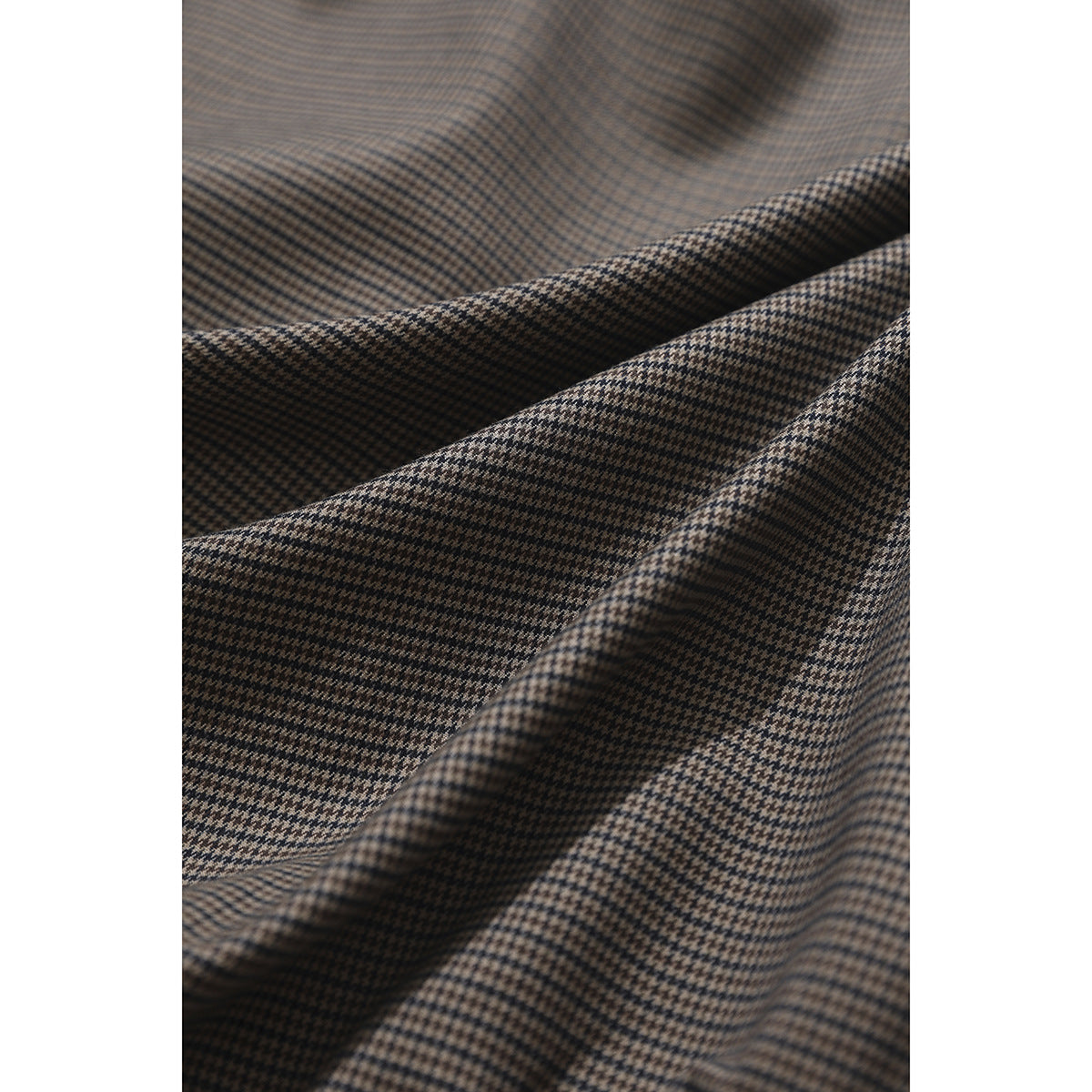 Macro view of the brown and black houndstooth pattern on jacket fabric.
