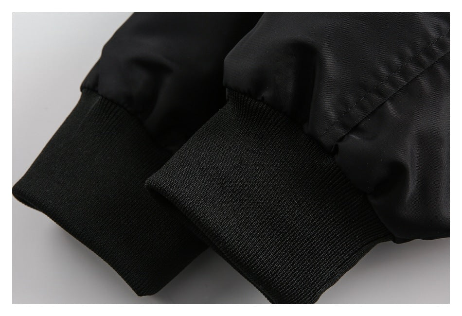 Close-up of two black ribbed jacket cuffs against smooth black sleeves.