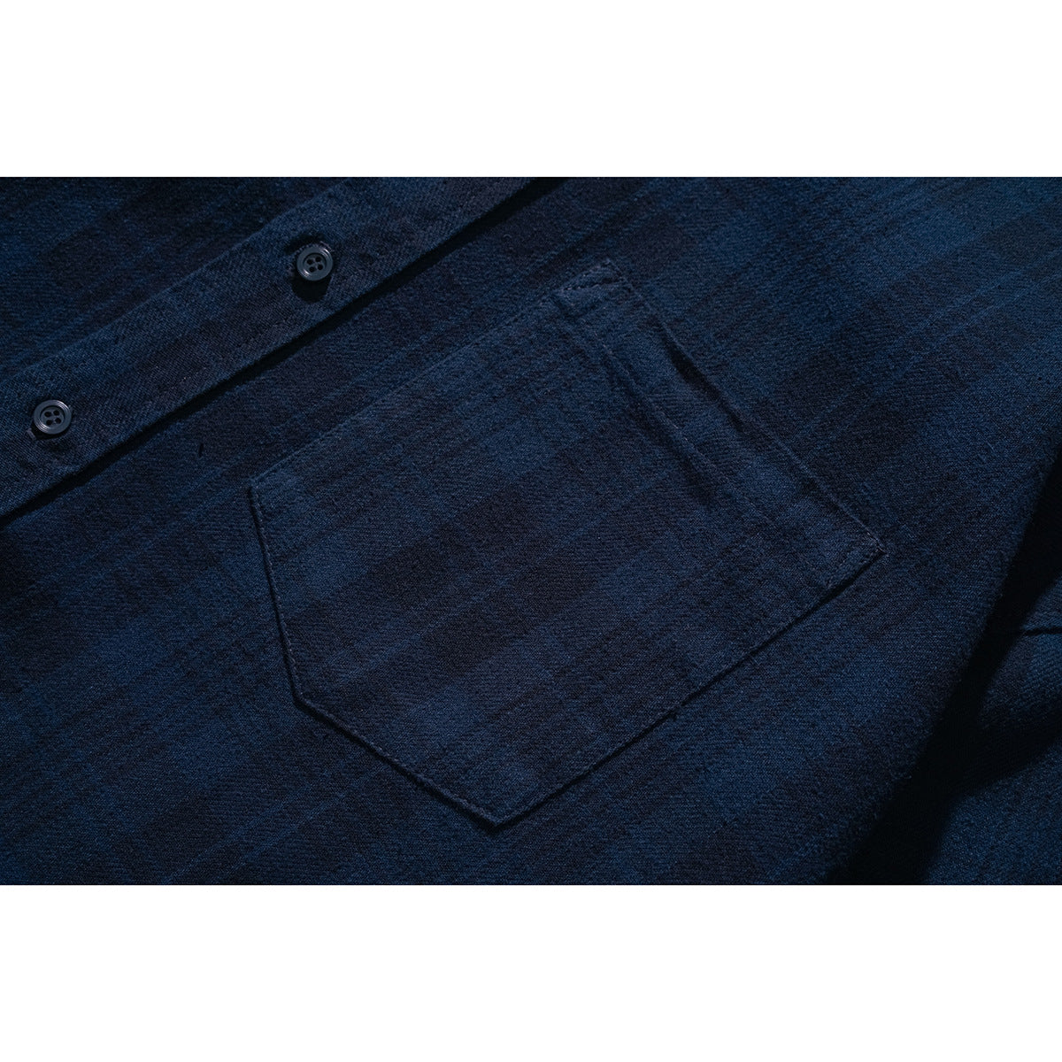 Close-up of a dark navy shirt's button placket and single chest pocket.