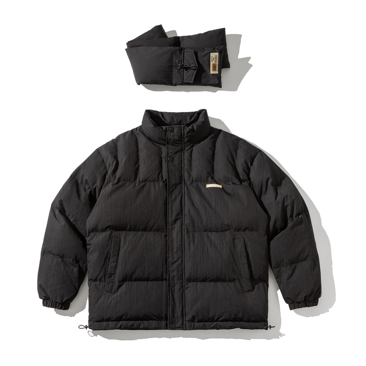 Black quilted stand-collar puffer jacket flat lay with a folded padded scarf above it