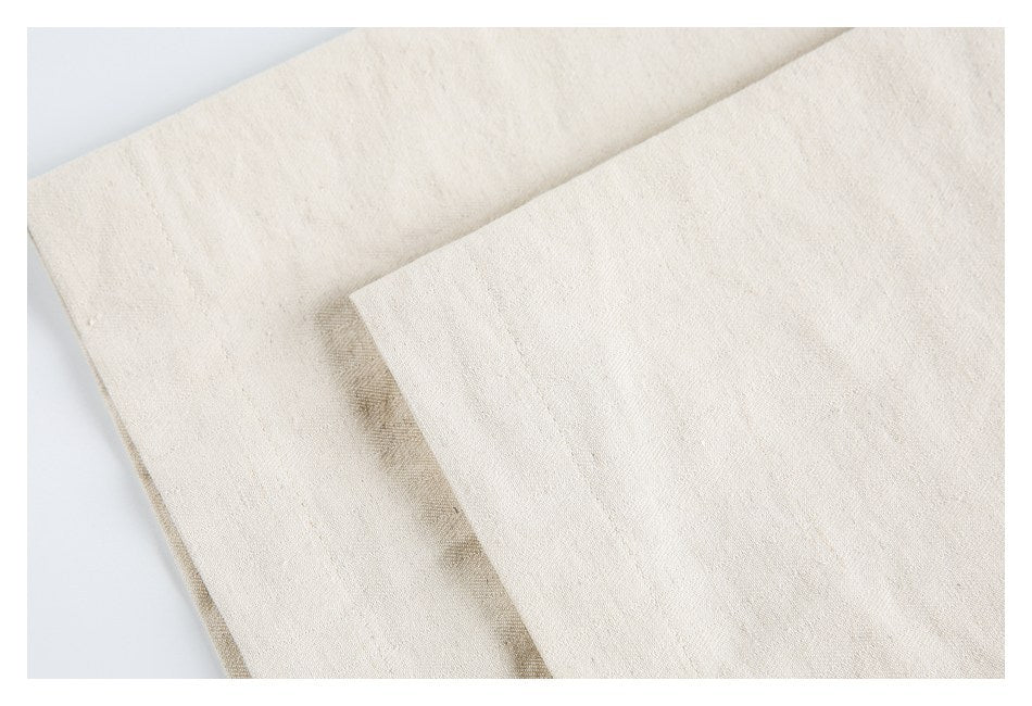 Close-up of layered fabric panels and seams on an off-white garment.
