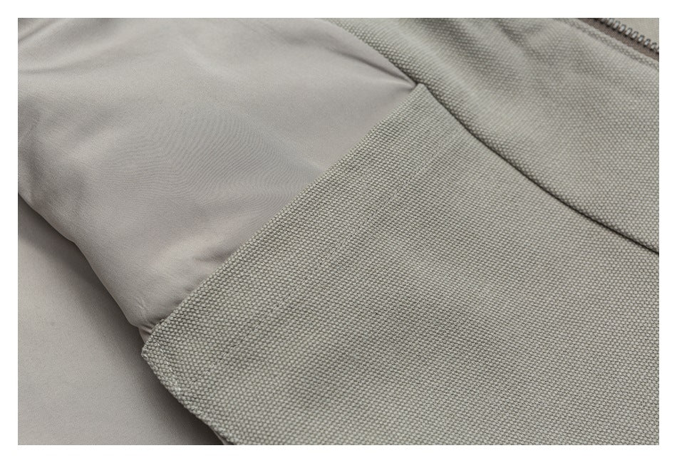 Close-up of the beige jacket interior, showing a smooth lining beside the textured outer fabric and zipper.