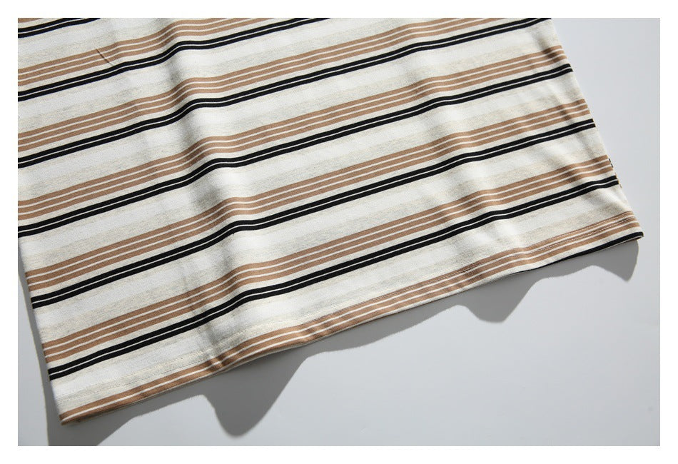 Close-up of the stitched lower hem on a cream shirt with black and brown stripes.