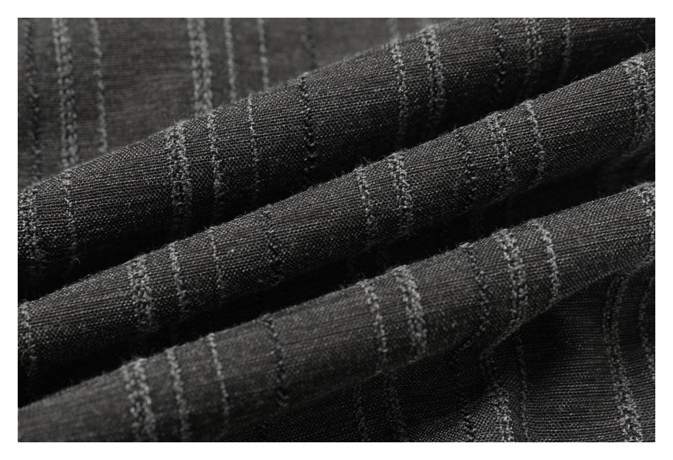 Macro view of charcoal fabric with narrow textured stripes folded into soft ridges.