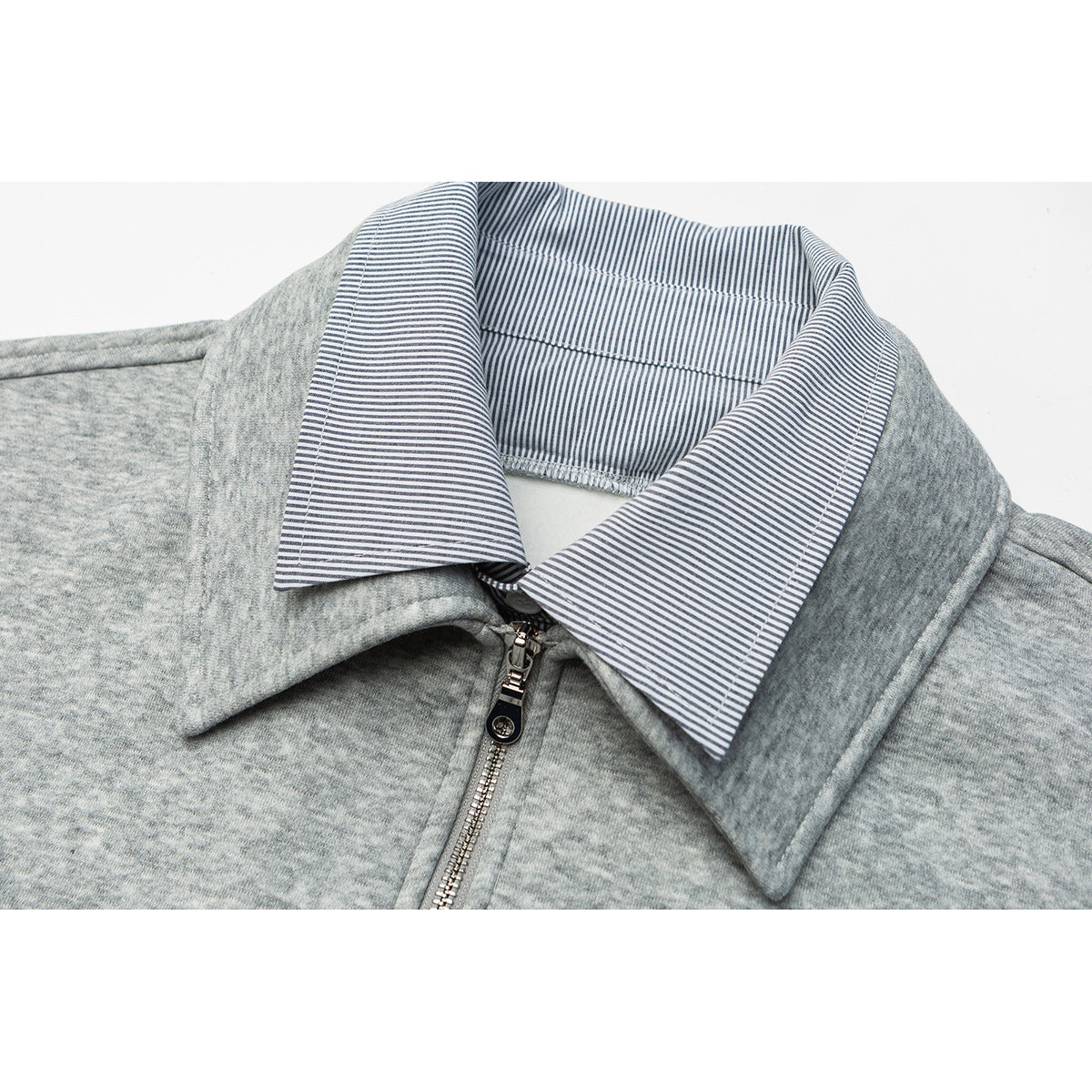 Close-up of a heather gray pullover collar with a blue-and-white striped lining and front zipper.
