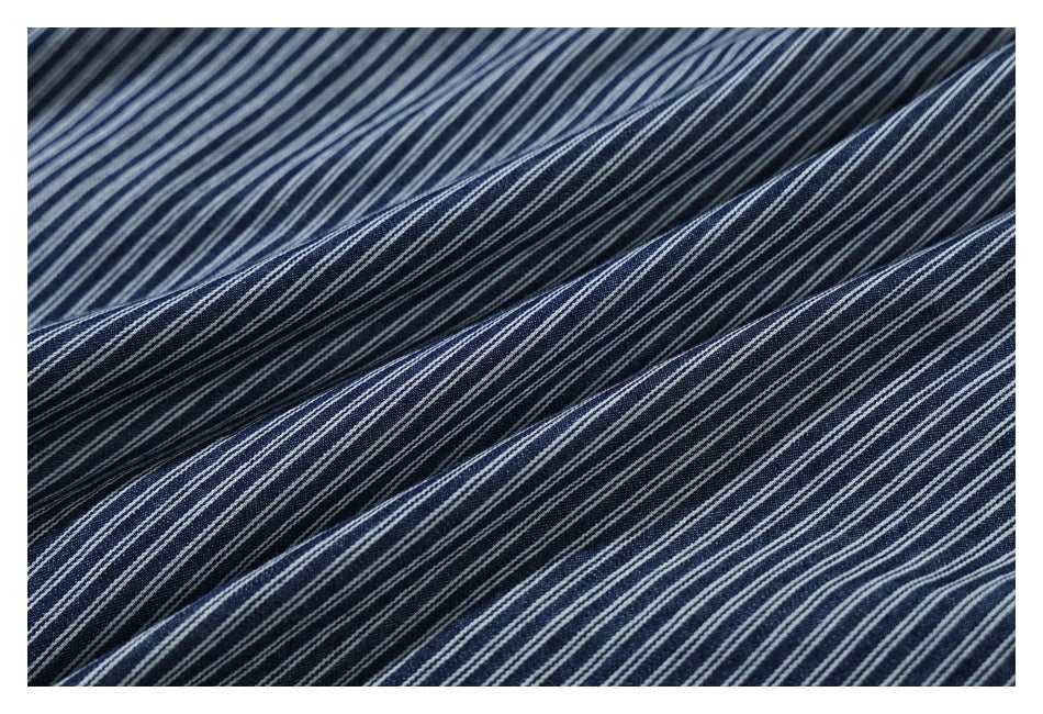 Close-up of navy fabric with fine white pinstripes draped in soft folds.