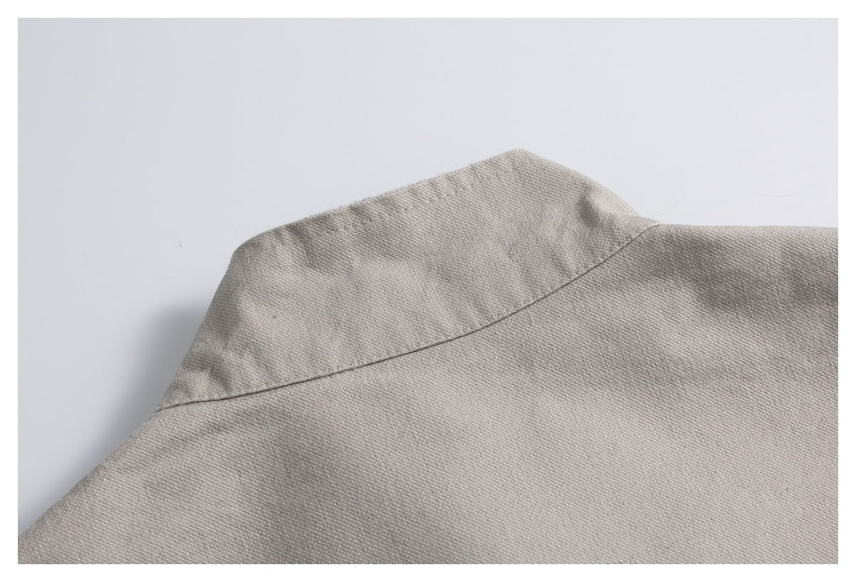 Close-up of the light gray garment's collar and stitched seam.