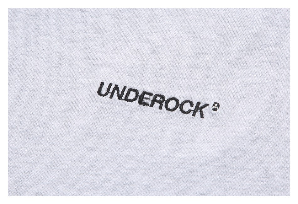 Close-up of black UNDEROCK lettering embroidered on light gray sweatshirt fabric.