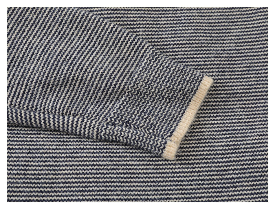 Close-up of navy and cream striped knit fabric with a folded edge finished in cream trim.