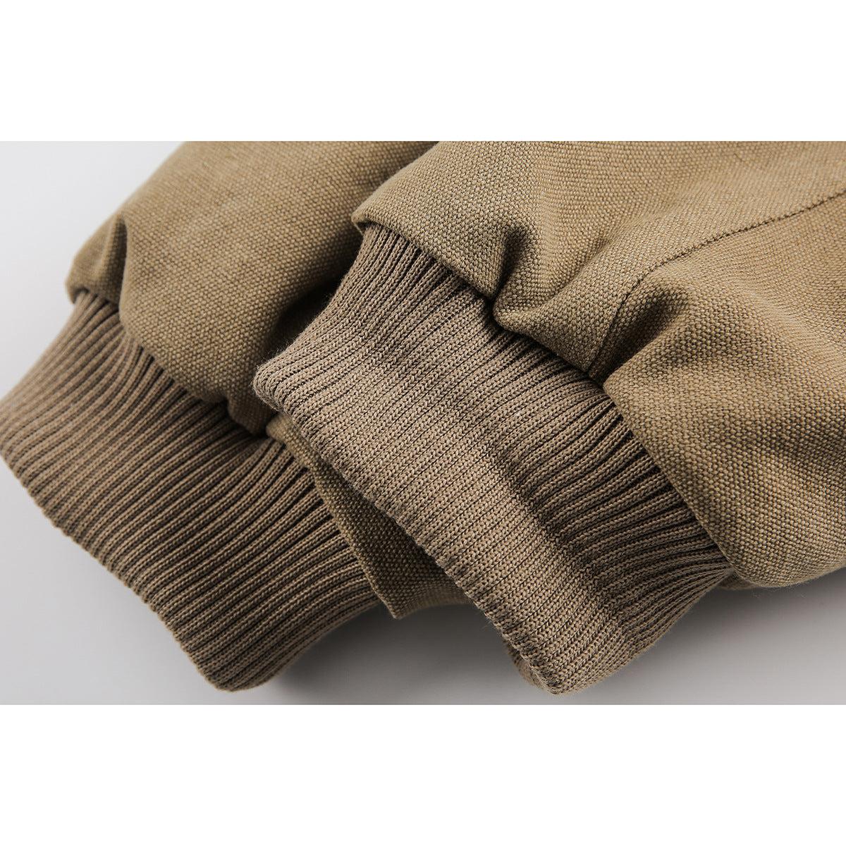 Close-up of ribbed cuffs and jacket fabric in tan.