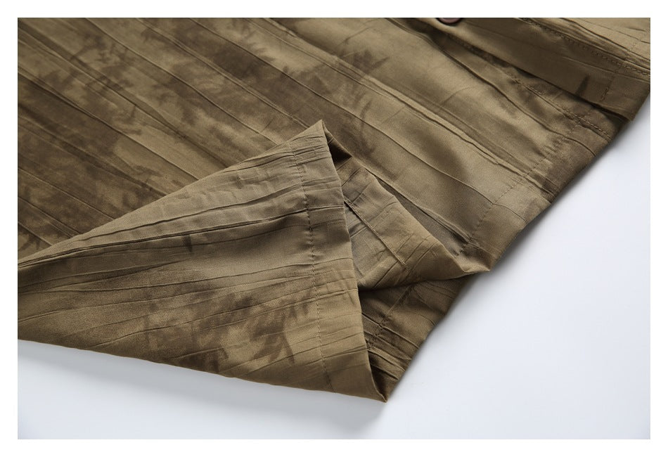Close-up of a folded edge and stitching on a brown abstract-patterned shirt.