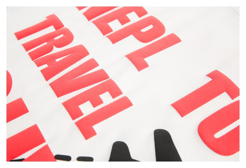Angled close-up of large red text and part of a black graphic on a white shirt.