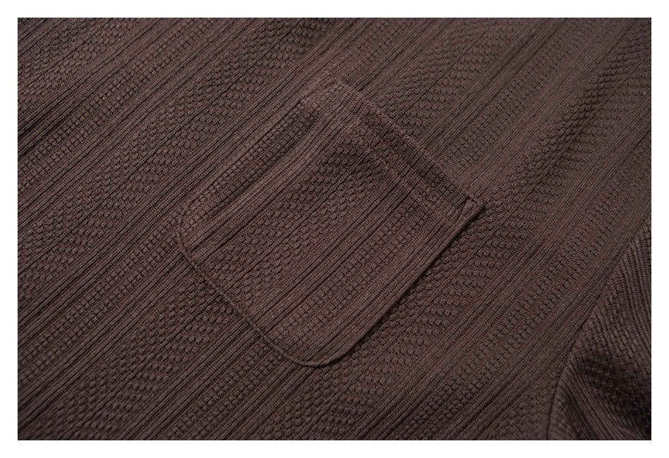 Close-up of the dark brown shirt's chest pocket against its textured fabric.