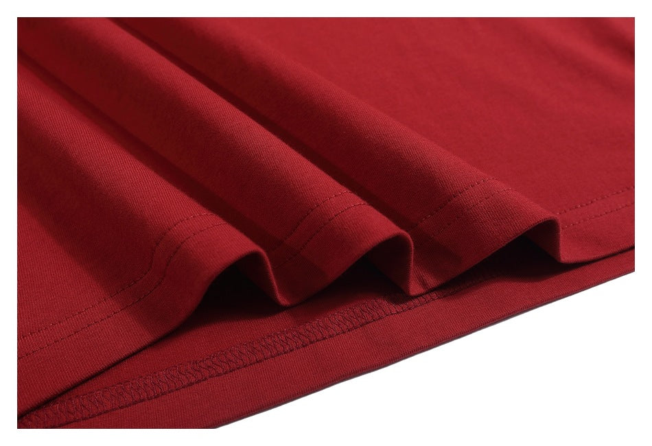 Close-up of the red T-shirt’s folded hem with visible stitching.