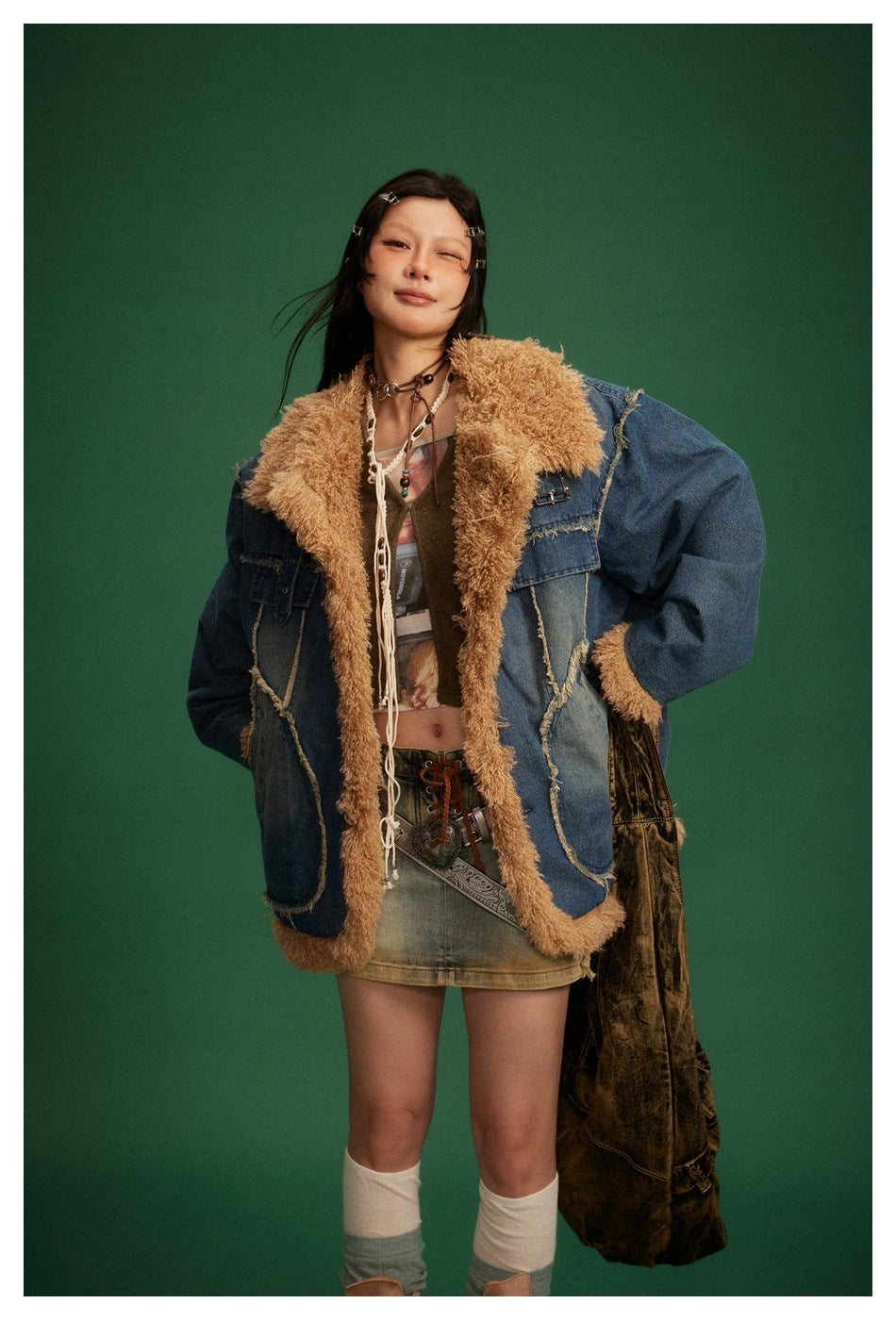 Model wearing an open blue denim jacket with a wide tan shaggy collar, trim, and large pockets.