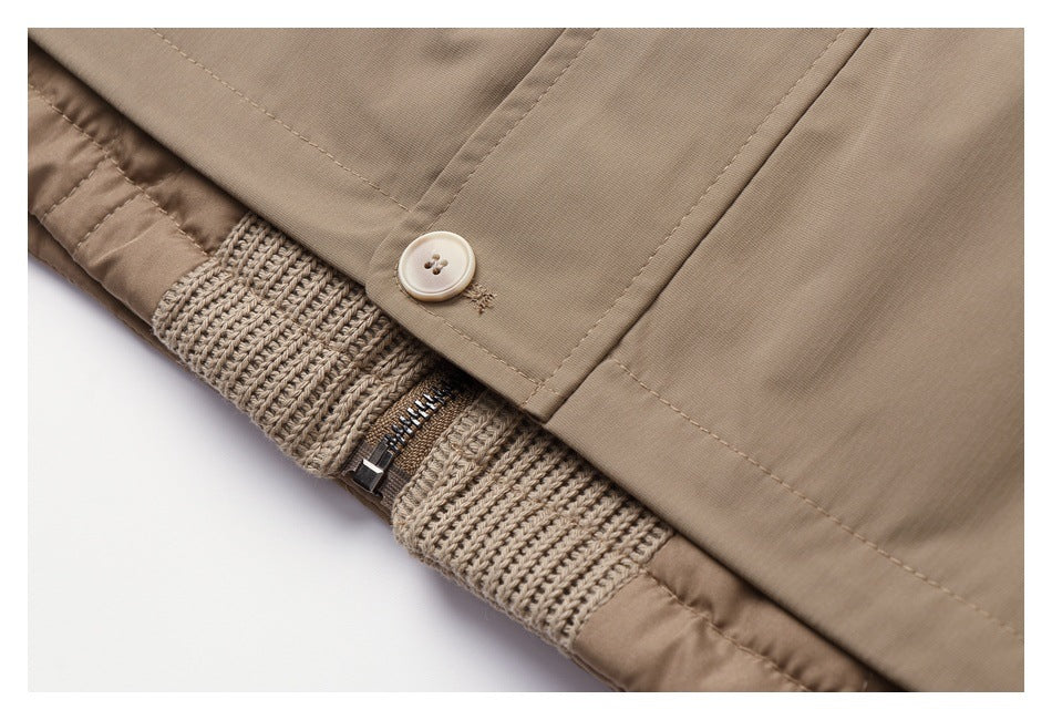 Close-up of a beige garment's buttoned edge, ribbed knit section and short zipper.
