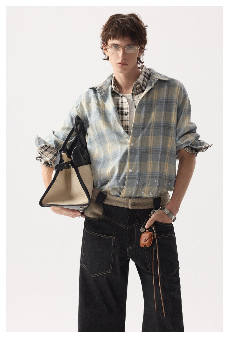 Front view of a model wearing a blue-gray plaid overshirt with pale yellow checks and white splatter details.