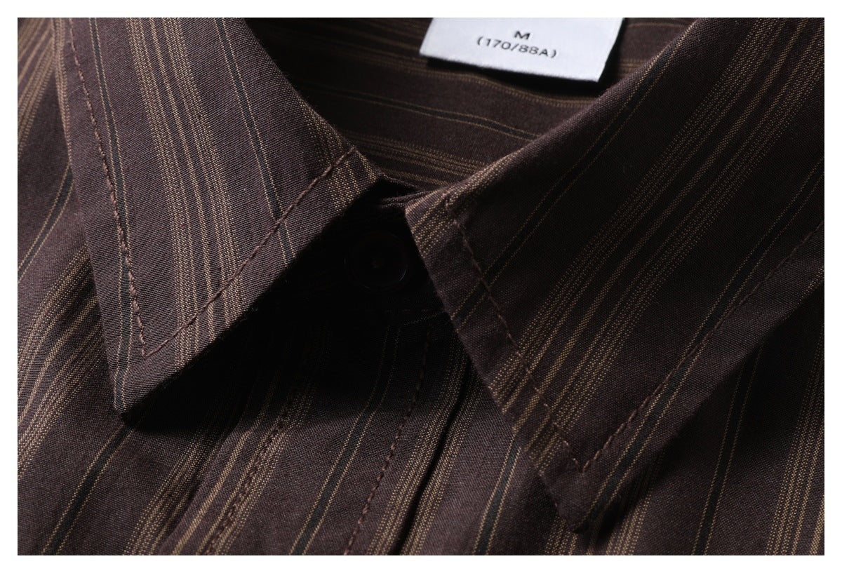 Close-up of the pointed collar and top button on a dark brown shirt with narrow tan stripes.
