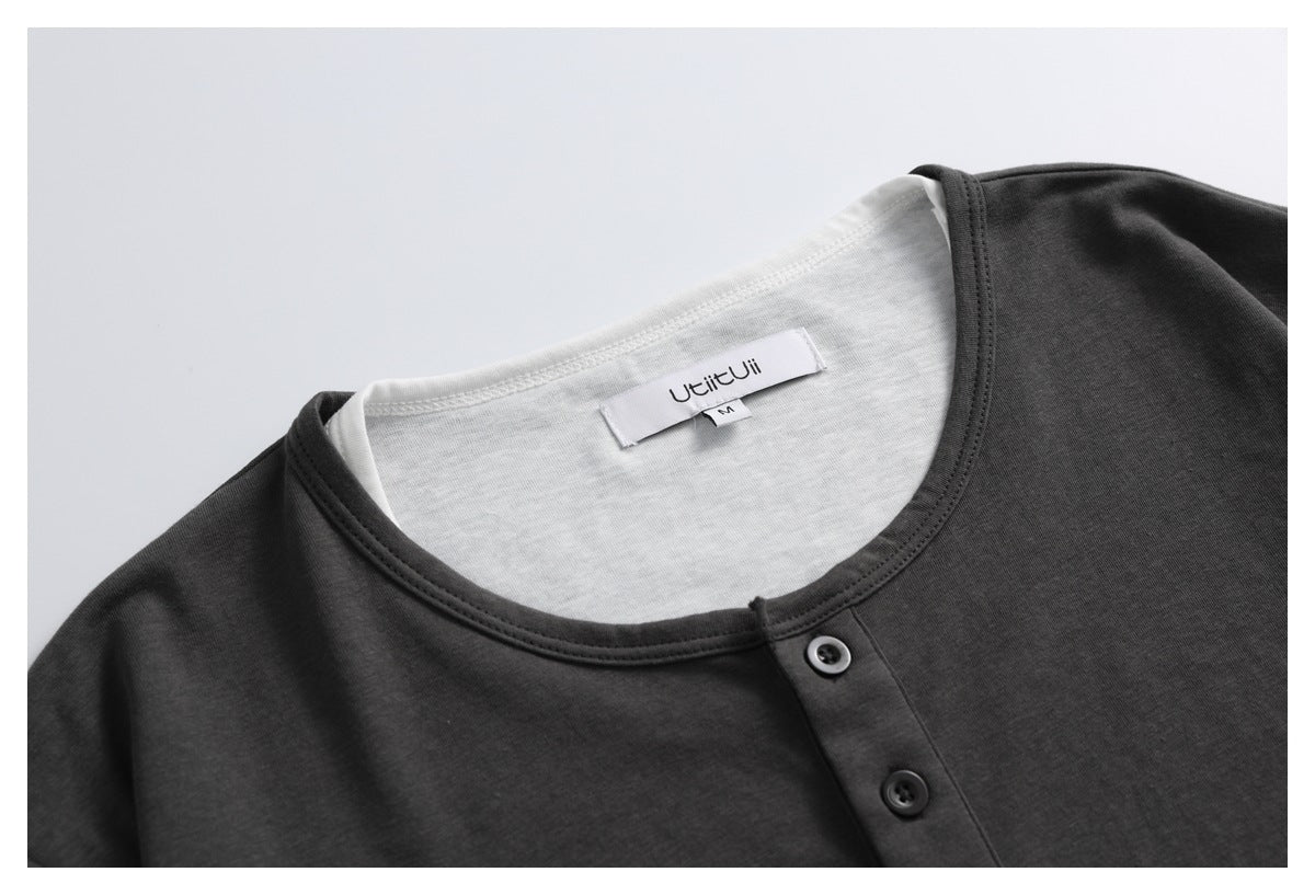 Close-up of a charcoal shirt's round neckline, two-button placket, and inner neck label.