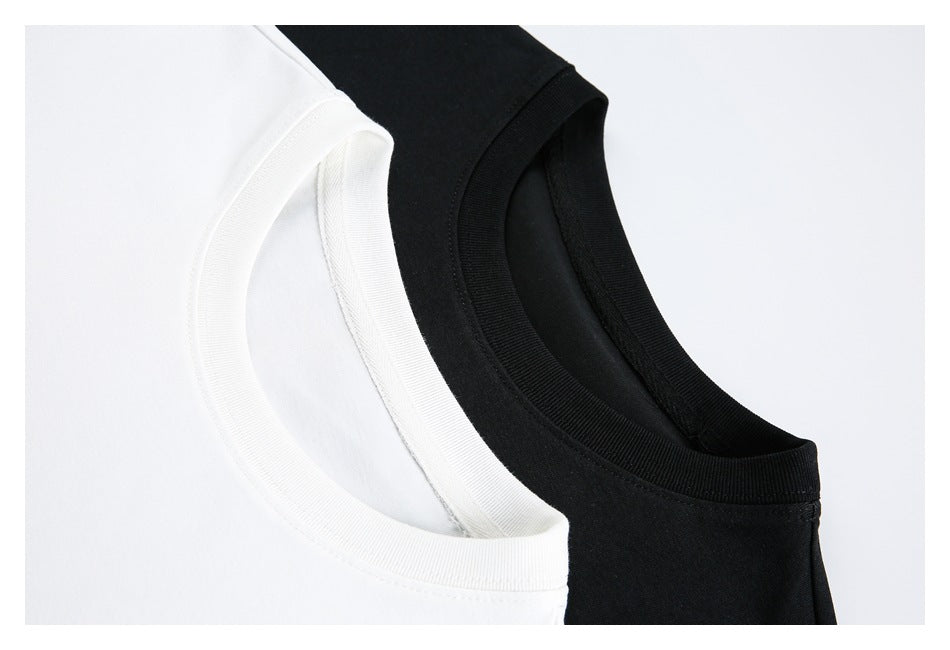 Close-up of overlapping white and black crew-neck T-shirts showing their ribbed collars.
