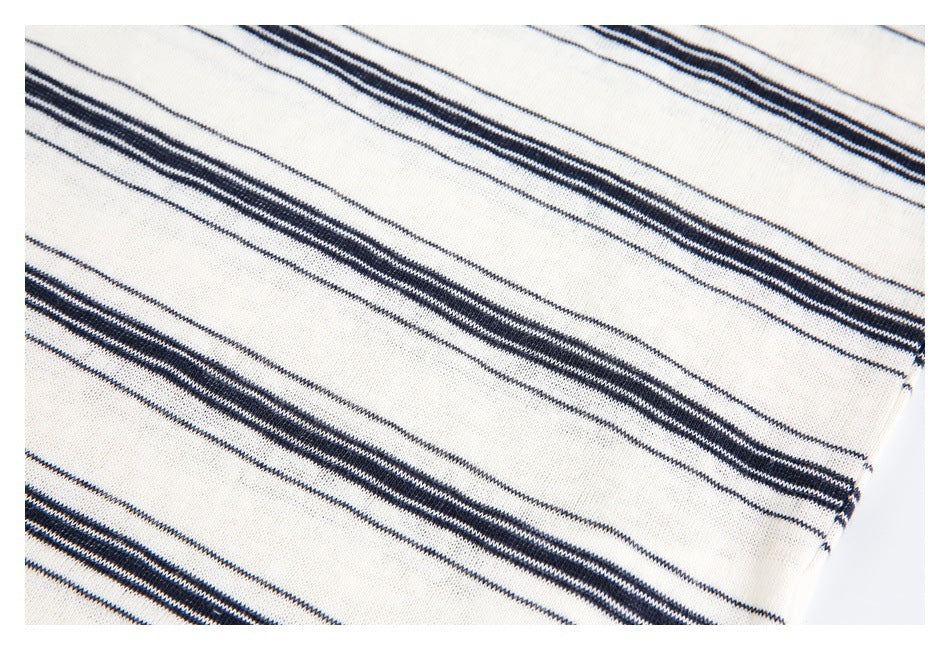 Close-up of the ivory garment's repeating narrow navy stripe pattern.