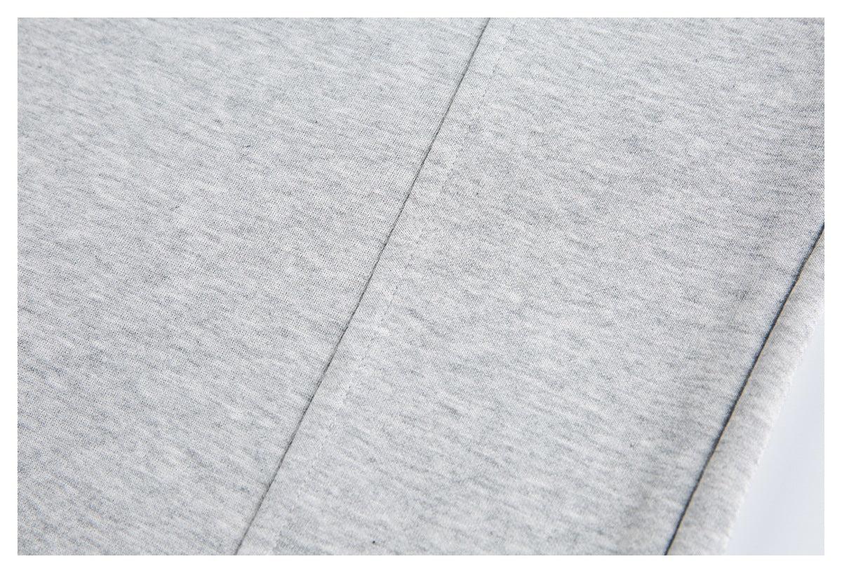 Close-up of light gray heathered knit fabric with parallel seam lines.