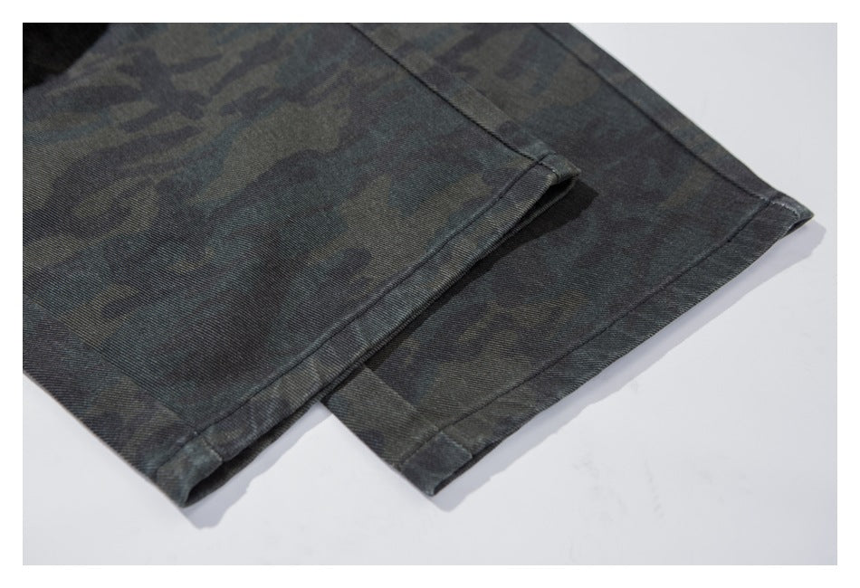 Close-up of the stitched hem on dark camouflage trousers.