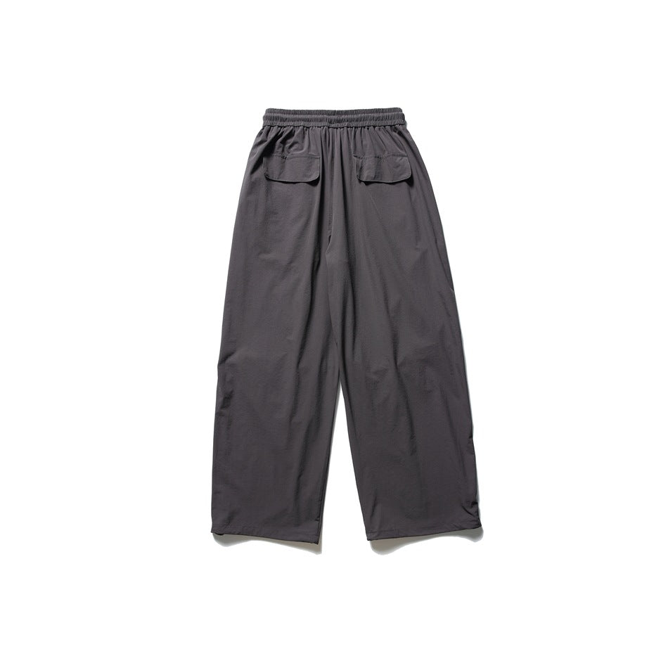 Back view of charcoal-gray wide-leg pants with an elastic waistband and two flap pockets.