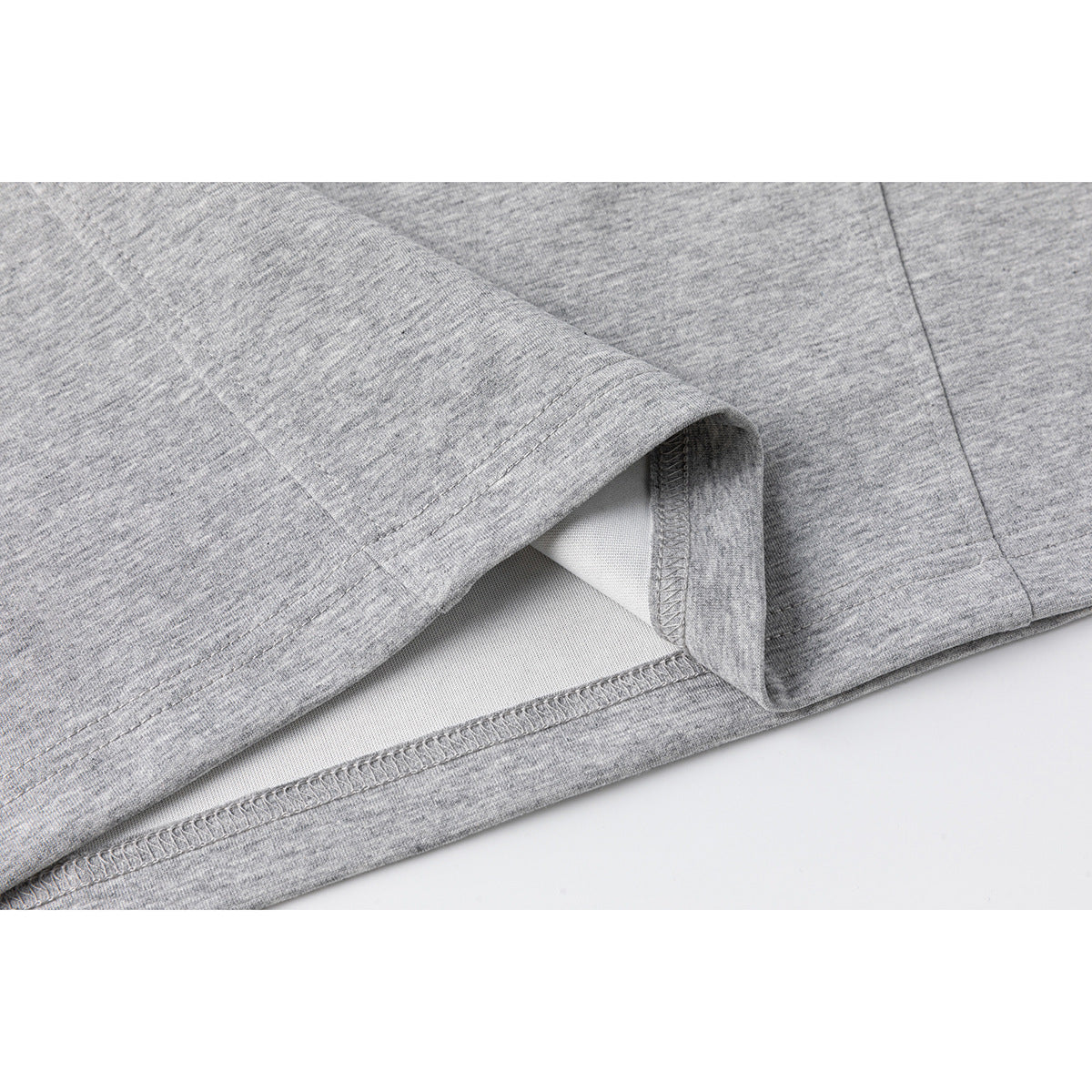 Close-up of a gray T-shirt hem showing the stitching and inside seam.