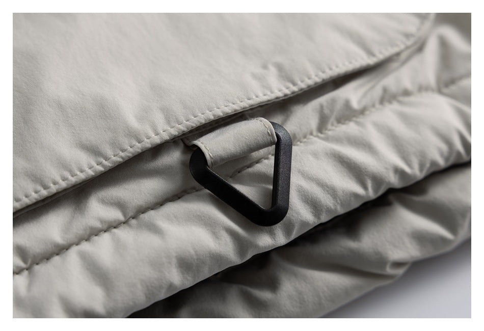 Close-up of a black triangular loop attached to pale gray padded fabric with a fabric tab.