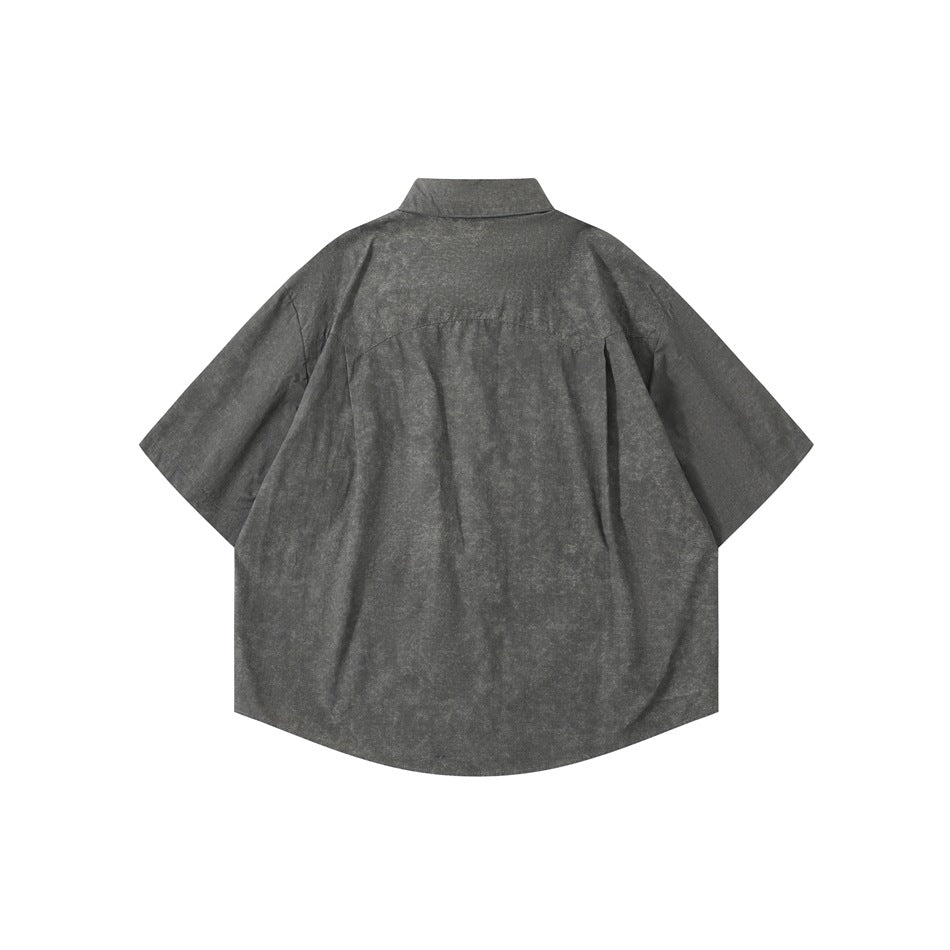 Back of a dark gray short-sleeve shirt with yoke seam and mottled texture, shown flat