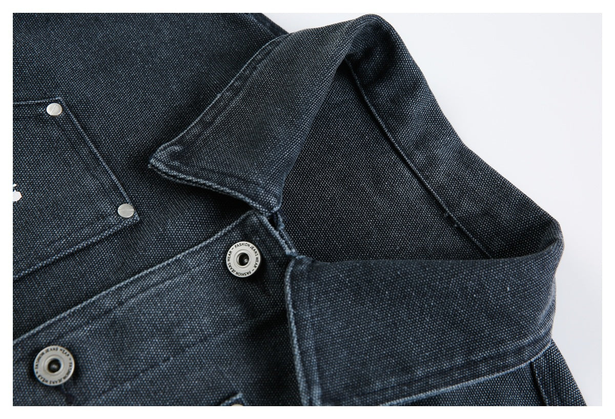Close-up of a dark textured jacket collar and upper front with silver snap buttons.