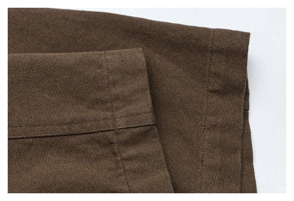 Close-up of a folded edge and stitching on the brown trousers.