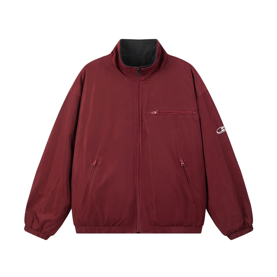 Burgundy red zip-up stand-collar jacket flat lay with zippered pockets, elastic cuffs and dark gray inner collar